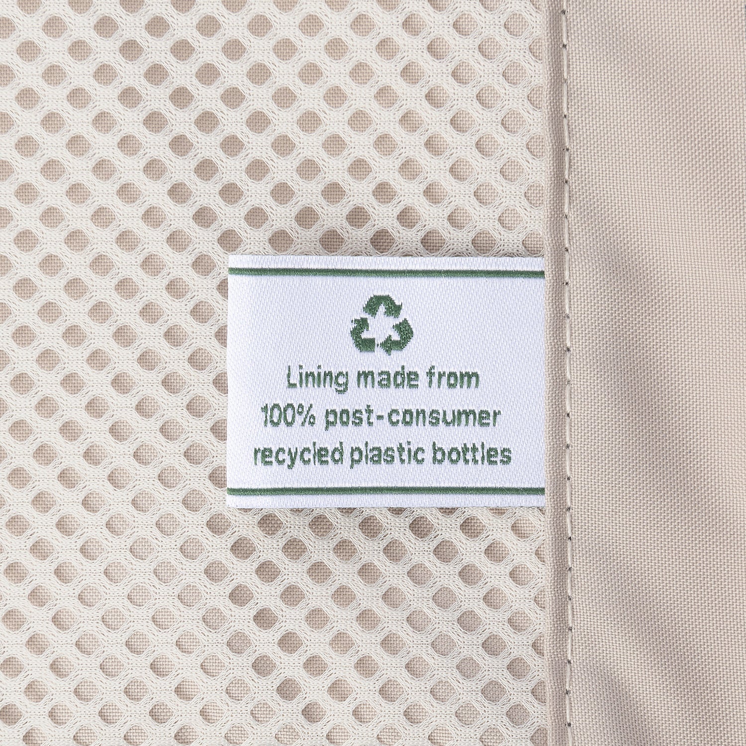 Close-up detail of the ECOFAB™ lining inside the Travelpro Platinum Elite Medium Check-In Hardside Spinner, showing a white fabric label that reads "Lining made from 100% post-consumer recycled plastic bottles" with a green recycling symbol.