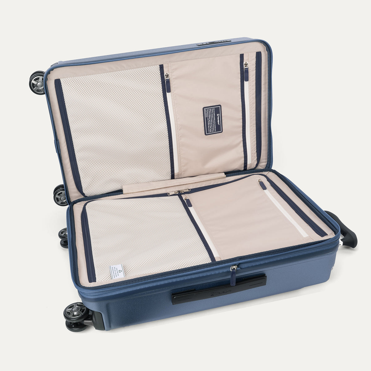 Interior packing view of the Travelpro Platinum Elite Medium Check-In Hardside Spinner in Dark Sky Blue, featuring dual zippered divider panels and the ECOFAB™ lining made from 100% recycled plastic bottles.