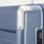 Close-up detail of the Travelpro Platinum Elite Medium Check-In Hardside Spinner in Dark Sky Blue, showing the integrated TSA-approved combination lock and protective polished aluminum corner armor.