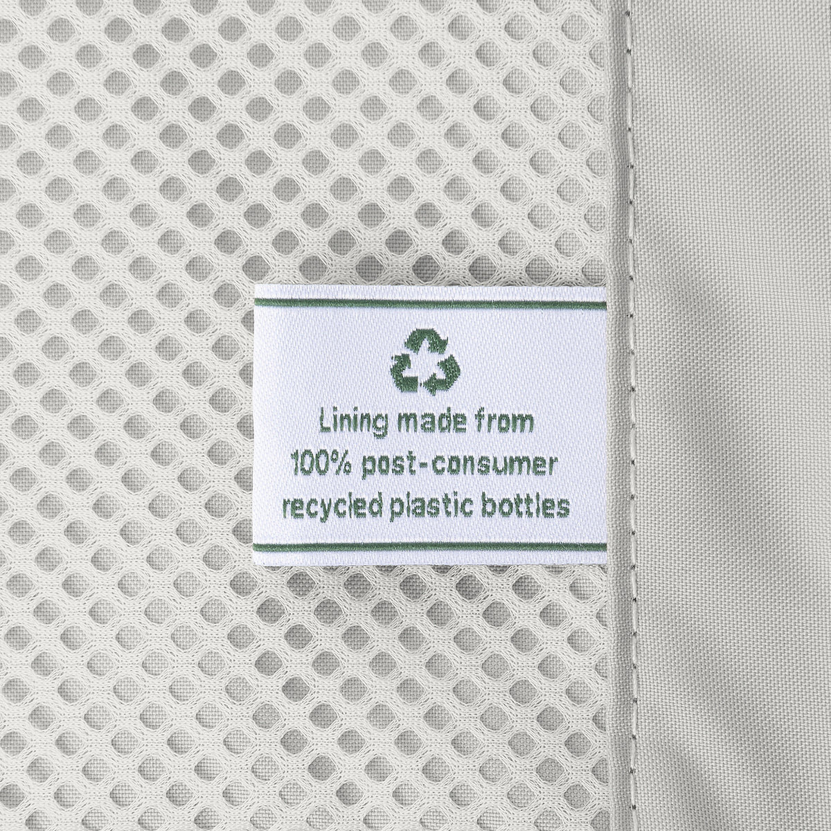 Close-up of the interior lining of the Travelpro Platinum Elite Medium Check-In Hardside Spinner in Jet Black, featuring a tag stating "Lining made from 100% post-consumer recycled plastic bottles" for the ECOFAB system.