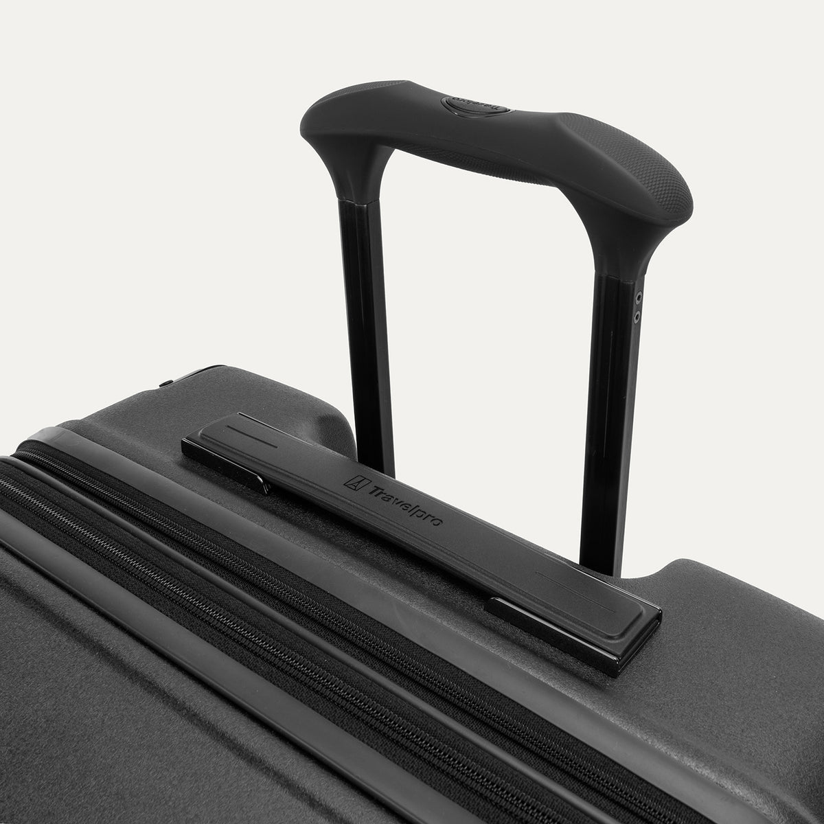Close-up of the Travelpro Platinum Elite Medium Check-In Hardside Spinner in Jet Black, featuring the multi-stop PowerScope Lite handle and the sleek, low-profile top carry handle with the Travelpro logo.