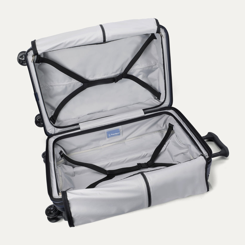 Open interior view of the Travelpro Platinum Elite Medium Check-In Hardside Spinner in Aviator Navy, showcasing the empty packing compartments, premium lining, and integrated tie-down straps.