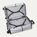 Open interior view of the Travelpro Platinum Elite Medium Check-In Hardside Spinner in Aviator Navy, showcasing the empty packing compartments, premium lining, and integrated tie-down straps.