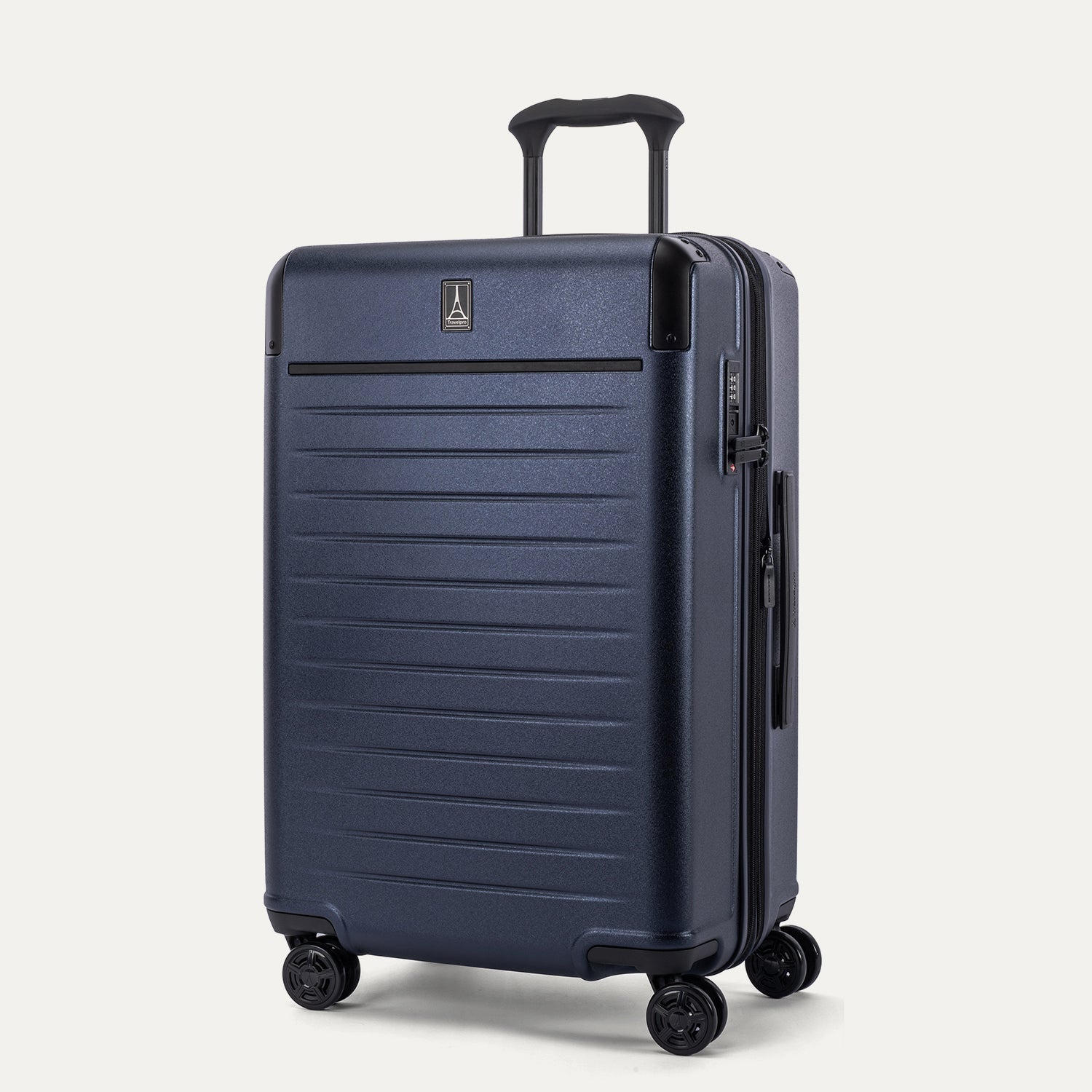Front 3/4 view of the Travelpro Platinum Elite Medium Check-In Hardside Spinner in Aviator Navy, featuring a scuff-resistant polycarbonate shell, aluminum corner armor, and 360-degree spinner wheels.
