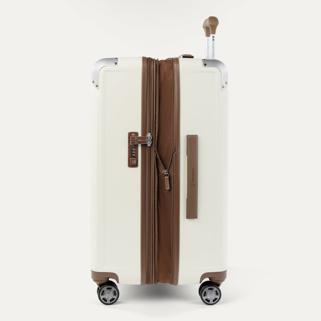"Side profile view of the Travelpro Platinum Elite Medium Check-In Hardside Spinner in Cream White, highlighting the zippered expansion capability, integrated TSA-approved lock, and brown leather-trimmed side carry handle."