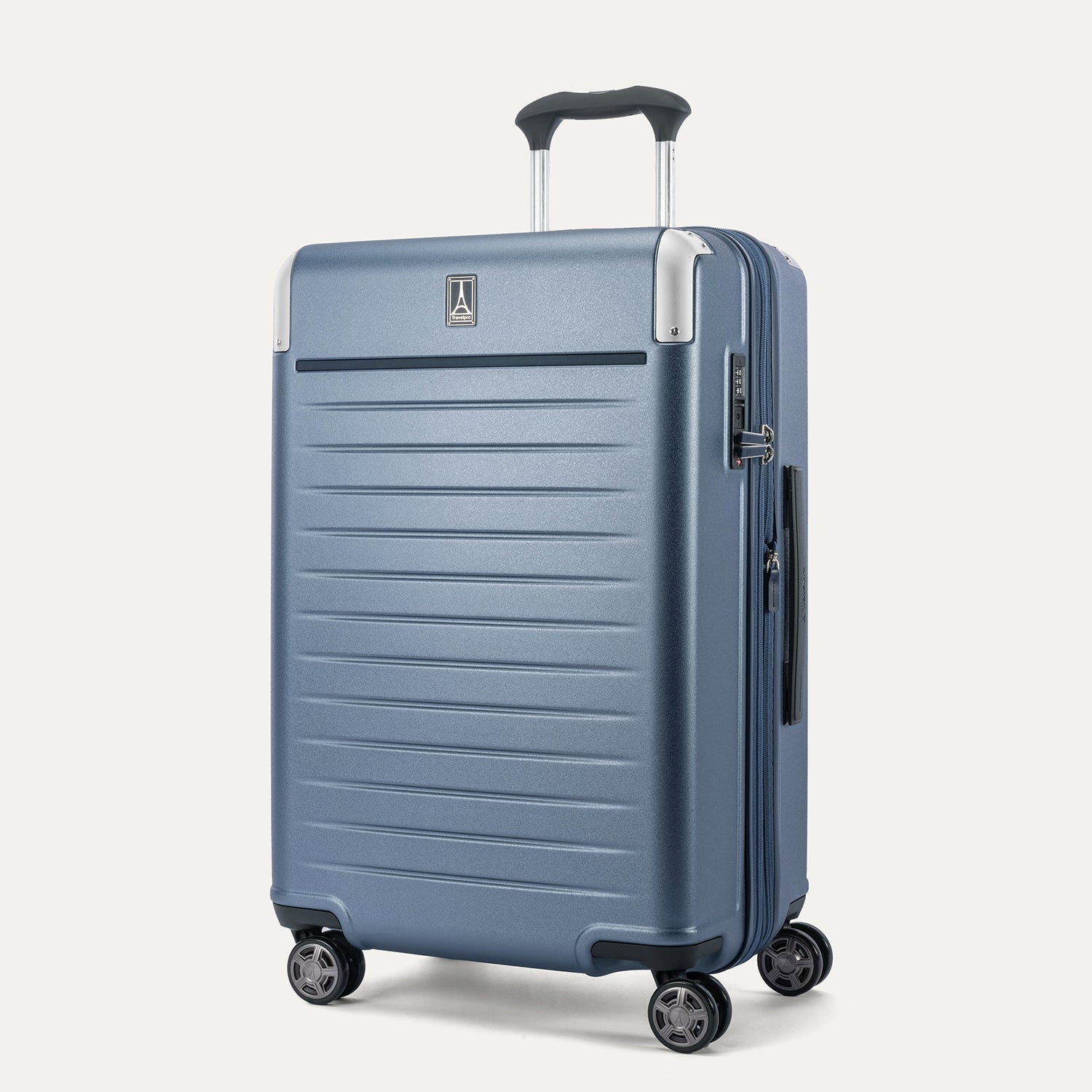Front 3/4 view of the Travelpro Platinum Elite Medium Check-In Hardside Spinner in Dark Sky Blue, featuring a scuff-resistant polycarbonate shell, aluminum corner armor, and 360-degree spinner wheels.
