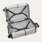 Open interior view of the empty Travelpro Platinum Elite Medium Check-In Hardside Spinner in Jet Black, showing the spacious dual packing compartments and premium interior lining.