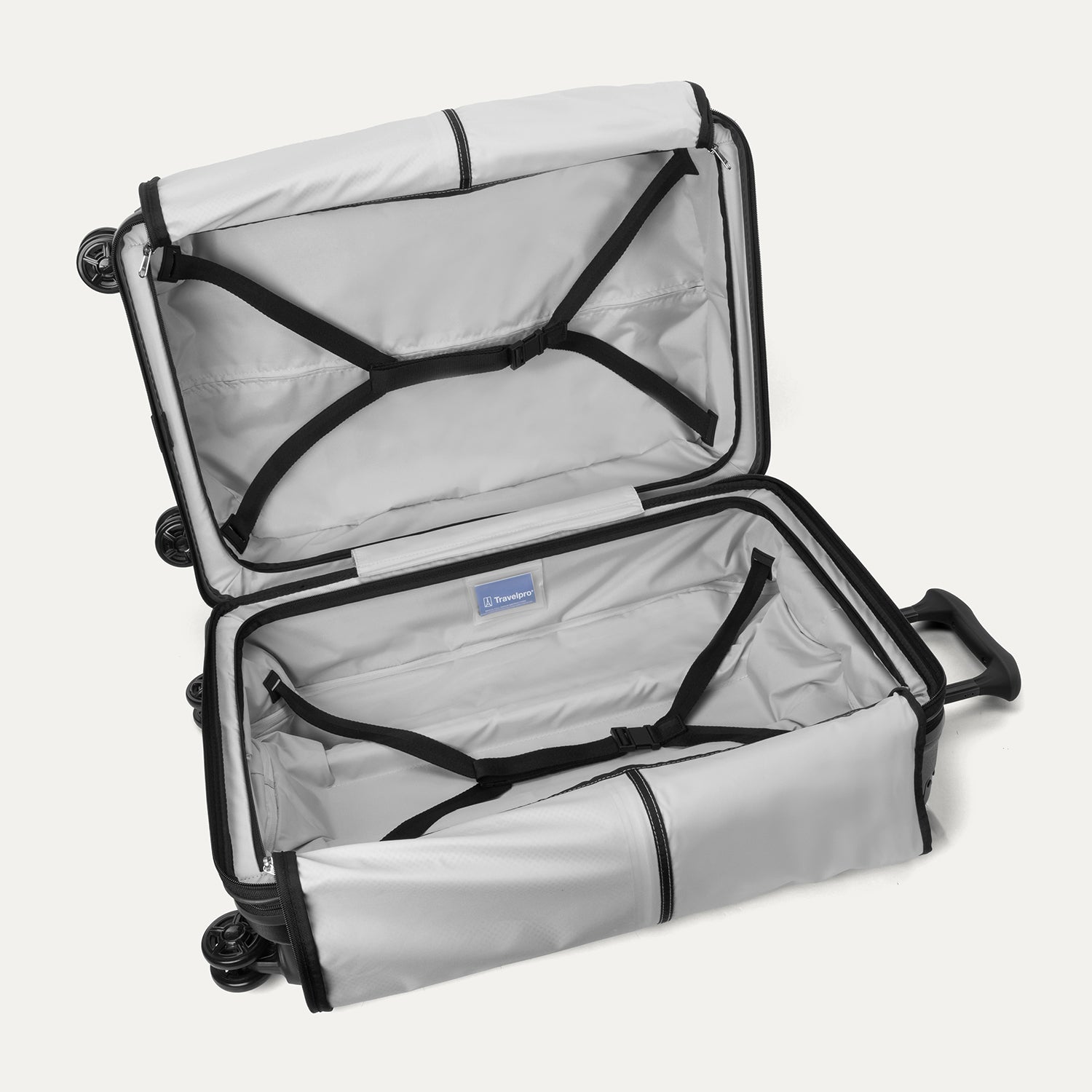 Fully open interior packing view of the Travelpro Platinum Elite Medium Check-In Hardside Spinner in Jet Black, showing dual zippered mesh divider panels and adjustable hold-down straps for organized travel.