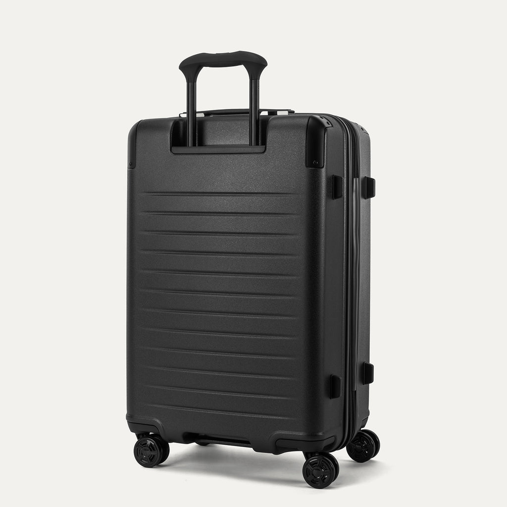 Rear 3/4 view of the Travelpro Platinum Elite Medium Check-In Hardside Spinner in Jet Black, featuring the sturdy PowerScope Lite handle and high-performance self-aligning spinner wheels.