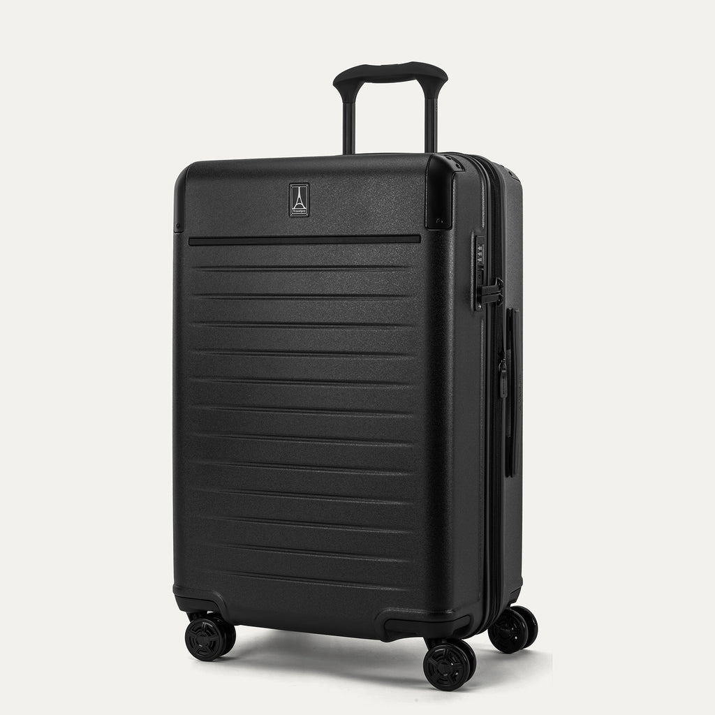 Front 3/4 view of the Travelpro Platinum Elite Medium Check-In Hardside Spinner in Jet Black, featuring a durable 100% polycarbonate shell, aluminum corner armor, and 360-degree MagnaTrac spinner wheels.