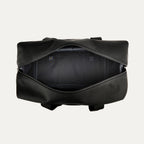 top-down view of the open shadow black travelpro platinum elite drop-bottom weekender bag, showing the spacious empty main compartment with a dark grey lining and interior zippered accessory pockets.