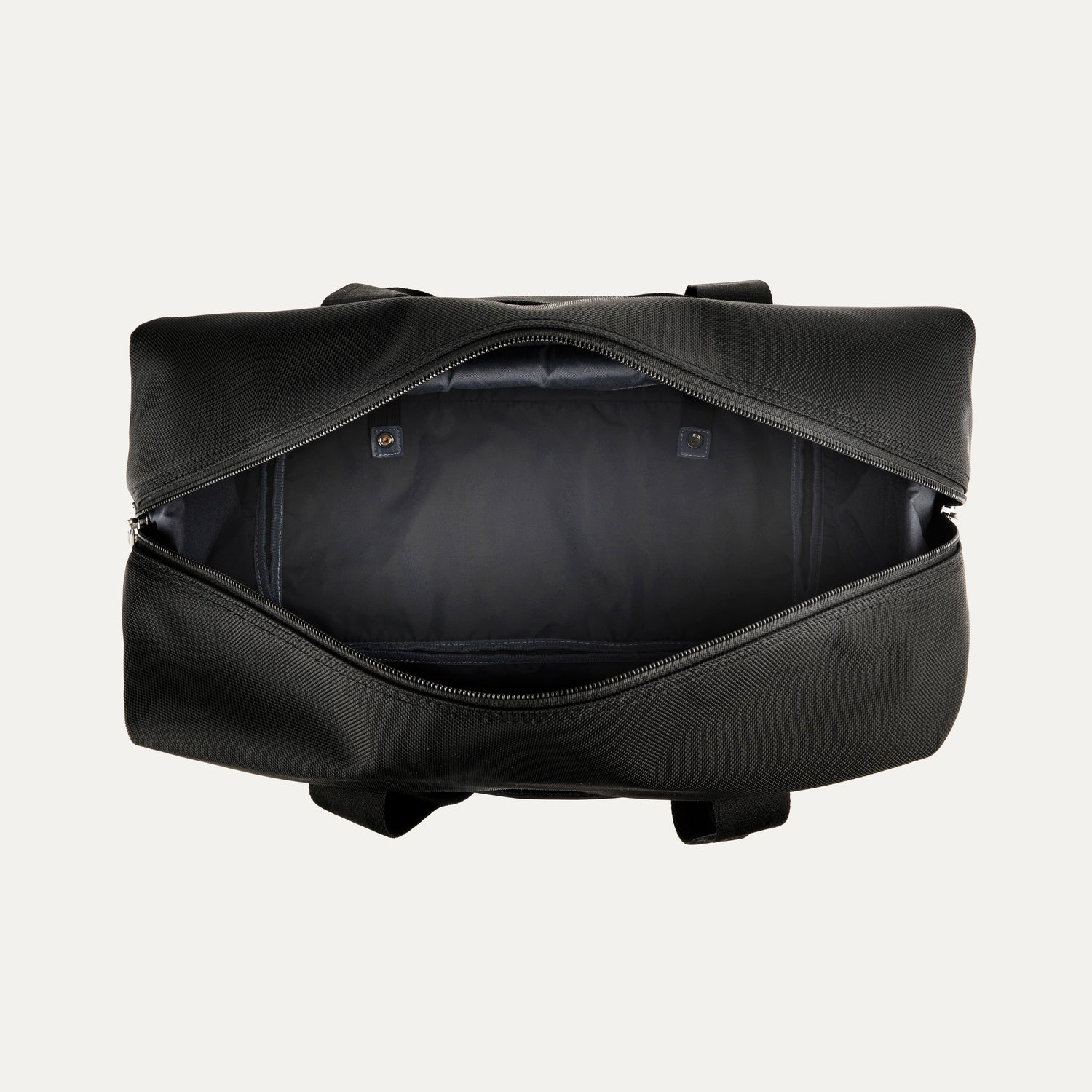 top-down view of the open shadow black travelpro platinum elite drop-bottom weekender bag, showing the spacious empty main compartment with a dark grey lining and interior zippered accessory pockets.