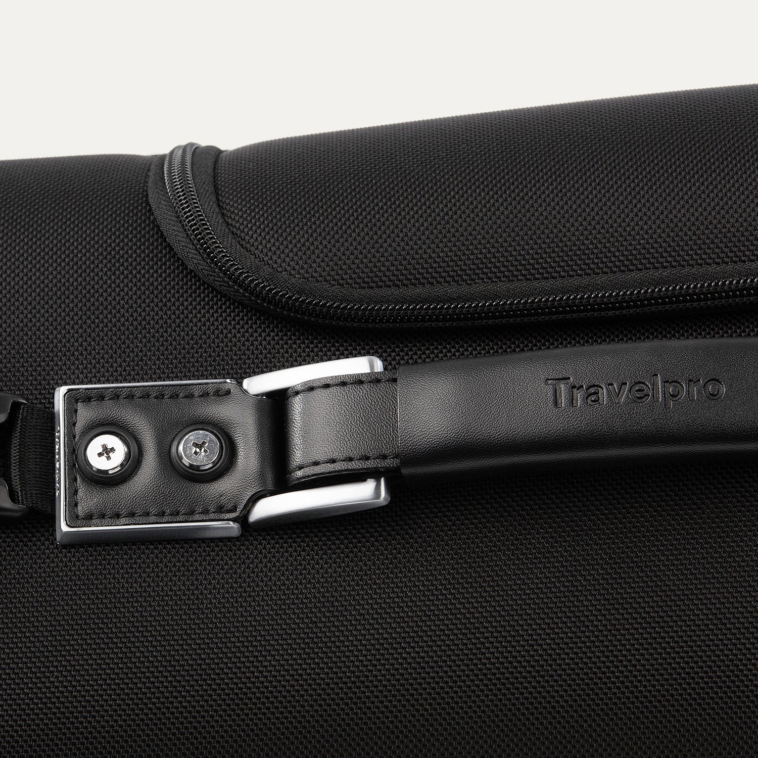 close-up view of the premium leather top carry handle on the shadow black travelpro platinum® elite rolling garment bag, showing the embossed travelpro logo and durable chrome-finished hardware.