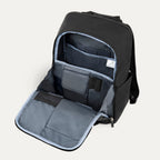 interior view of the front organizational compartment of the shadow black travelpro platinum® elite slim laptop backpack 16l, showing dedicated pockets for pens, small electronics, and a zippered mesh security pocket against a light grey lining.