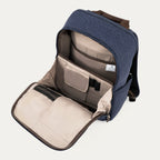 interior view of the open front organizational compartment of the true navy travelpro platinum® elite slim laptop backpack 16l, showing dedicated pockets for pens, small electronics, and a zippered mesh security pocket against a light grey lining.