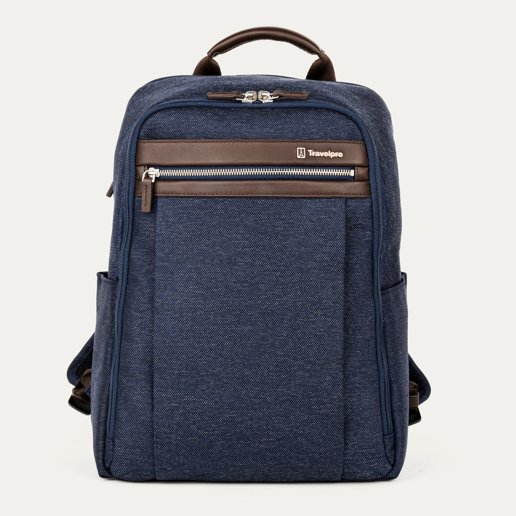 front hero view of the true navy travelpro platinum® elite slim laptop backpack 16l, featuring a textured navy blue fabric exterior with premium dark brown leather accents on the top handle and front zipper trim.