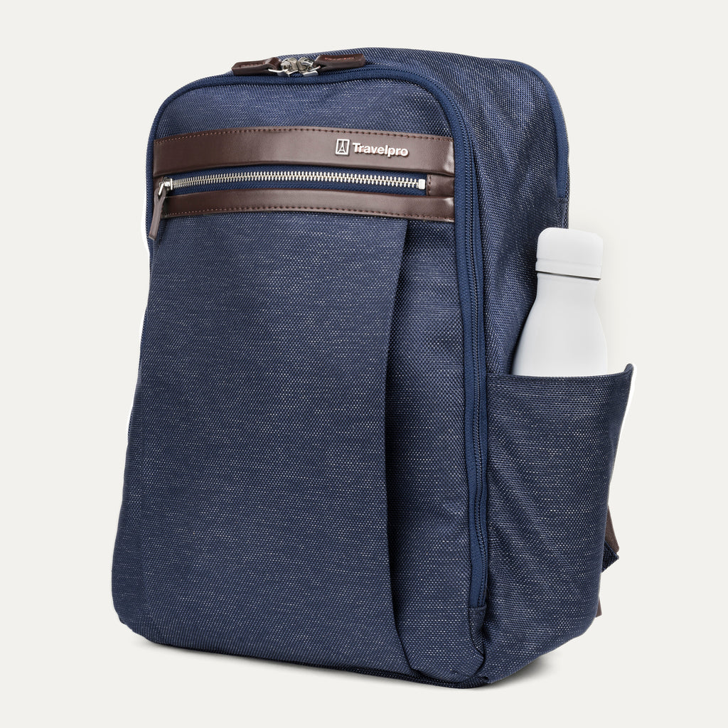 side profile of the true navy travelpro platinum® elite slim laptop backpack 16l, showing a white reusable water bottle tucked into the integrated side pocket with dark brown leather trim.