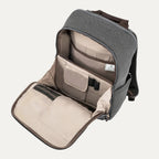 interior view of the open front organizational compartment of the vintage grey travelpro platinum® elite slim laptop backpack 16l, showing dedicated pockets for pens, small electronics, and a zippered mesh security pocket against a light grey lining.