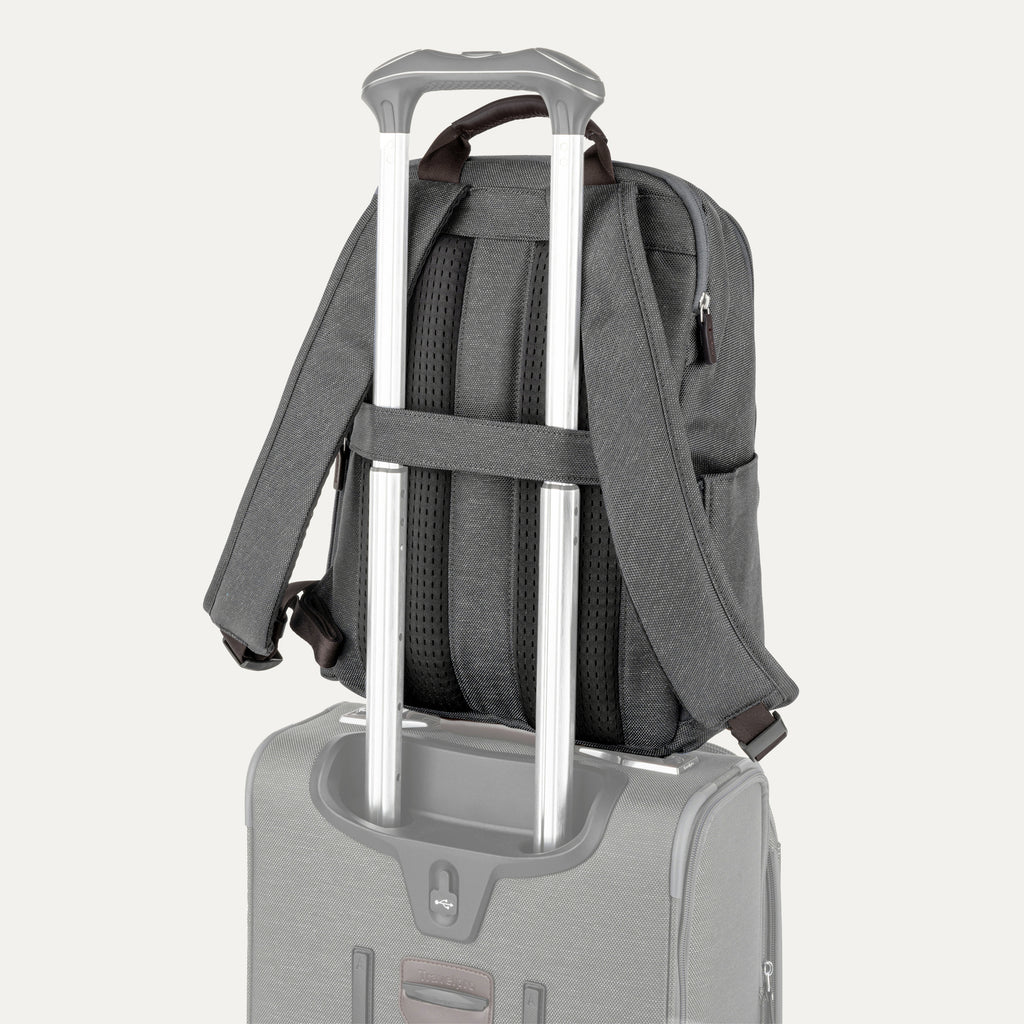 rear view of the vintage grey travelpro platinum® elite slim laptop backpack 16l stacked on a grey rolling suitcase, showing the integrated trolley strap with dark brown leather accents secured over the extension handle.