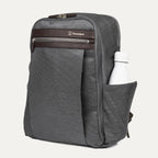 side profile of the vintage grey travelpro platinum® elite slim laptop backpack 16l, showing a white reusable water bottle tucked into the integrated side pocket with dark brown leather trim.