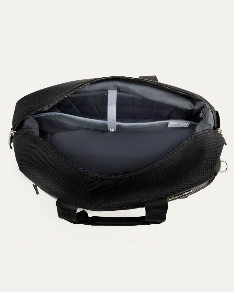 interior view of the open black travelpro platinum elite underseat tote, showing the spacious main compartment with a grey lining and a small leather-trimmed internal pocket.