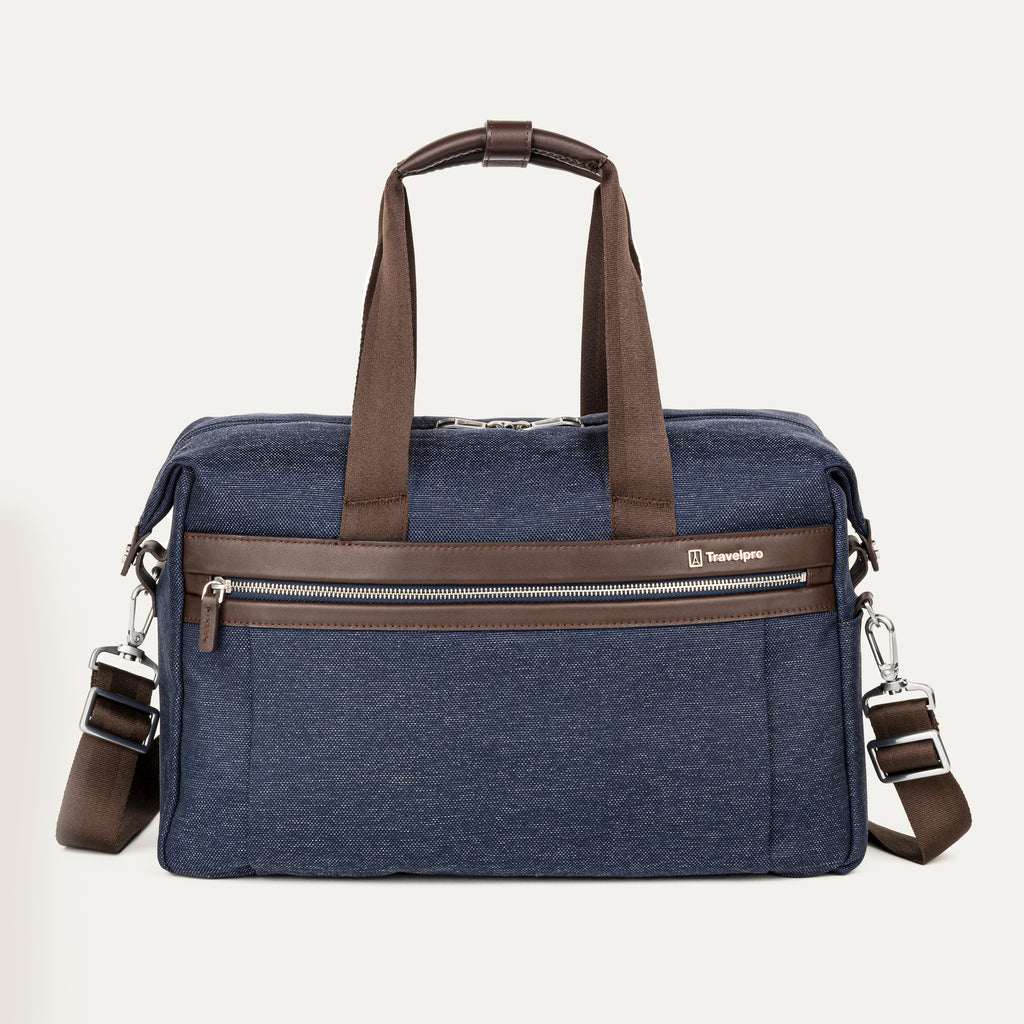 front view of the true navy travelpro platinum elite underseat tote featuring a textured blue fabric, brown leather trim and handles, chrome hardware, and a removable shoulder strap.