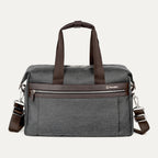 front view of the vintage grey travelpro platinum elite underseat tote featuring a textured grey fabric, brown leather trim and handles, chrome hardware, and a removable shoulder strap.