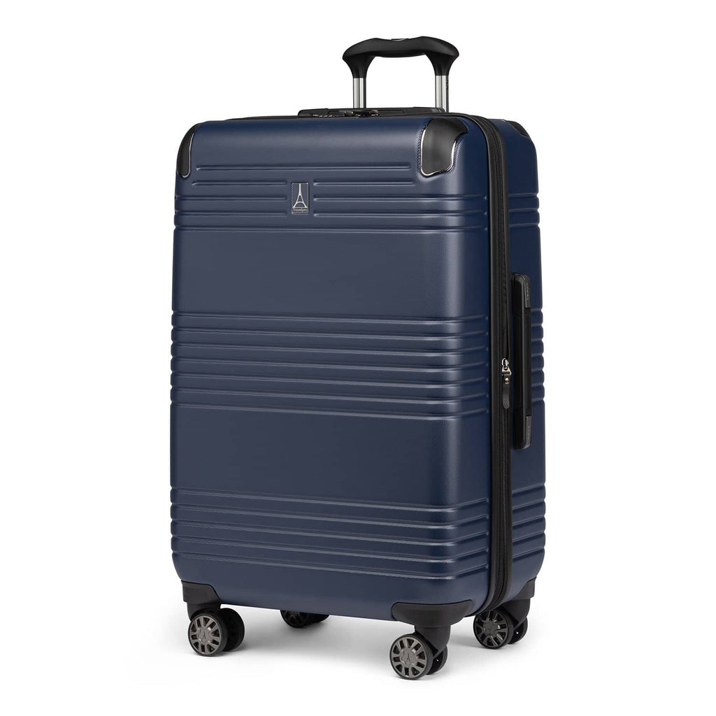 Three‑quarter front view of Travelpro Roundtrip Medium Check‑In Expandable Spinner in Navy, showing textured hardshell design, black trim, four spinner wheels, and telescoping handle against white background.