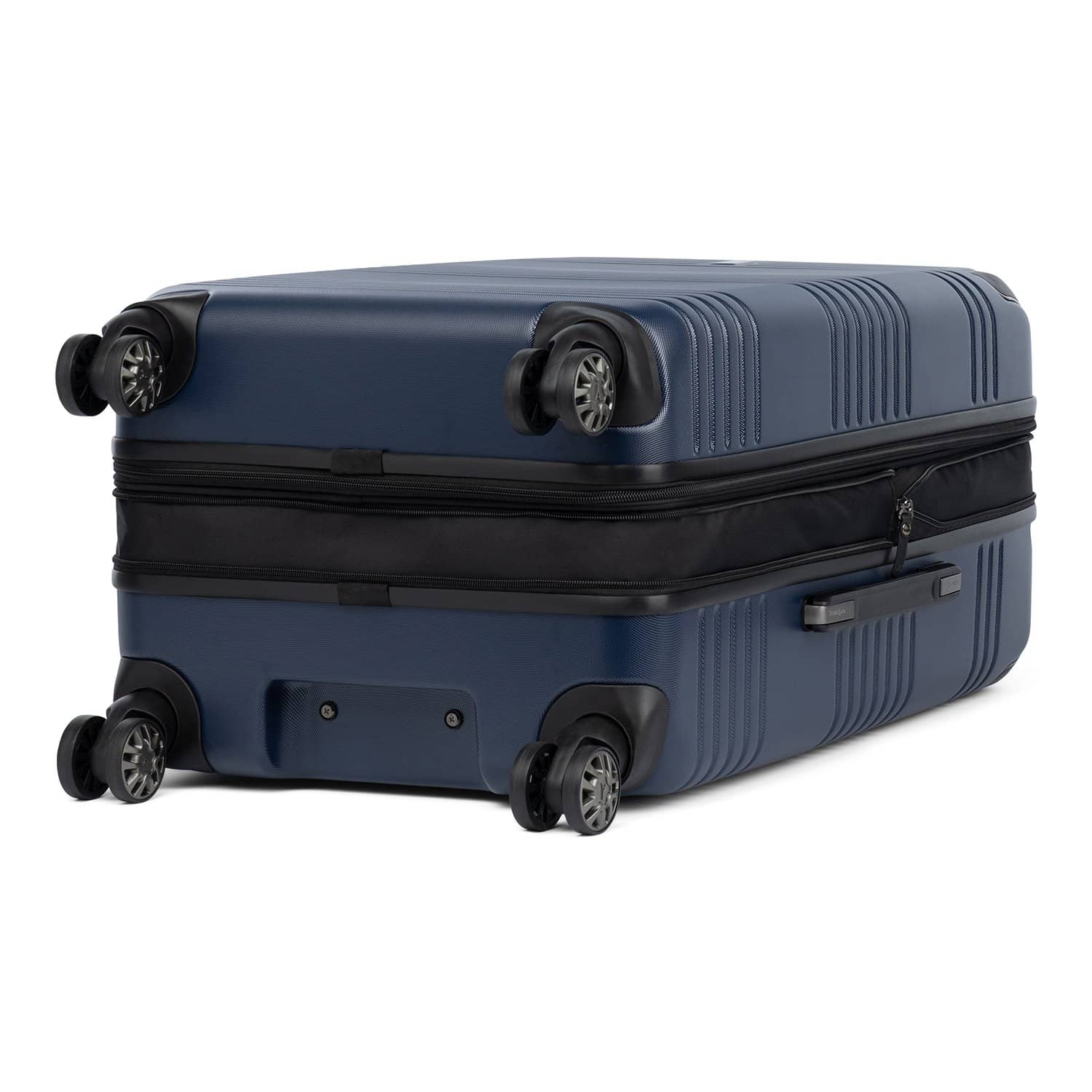 Bottom view of Travelpro Roundtrip Medium Check‑In Expandable Spinner in Navy, showing textured hardshell design, four spinner wheels, and expansion zipper against white background.